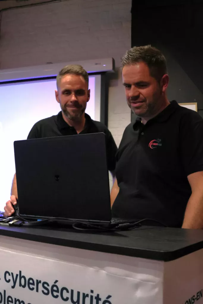 David Plankeele et Guy, de CyberIris, devant un ordinateur portable lors d’une matinale cybersécurité